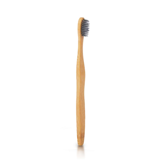 Beige bamboo toothbrush with charcoal bristles for natural whitening
